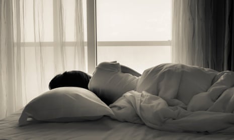 Young woman sleeping in bed beside the window.