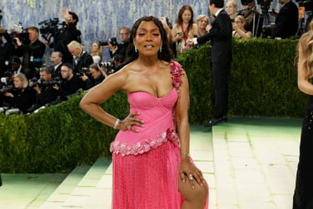 Angela Bassett posing on steps wearing pink dress
