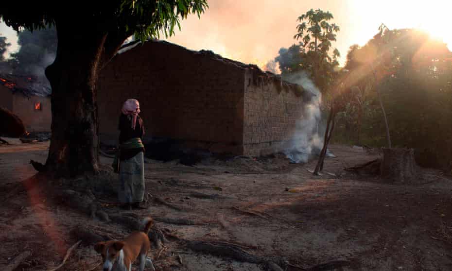 A woman looks at burning houses in the town of Bossangoa, north of Bangui, the Central African Republic’s capital