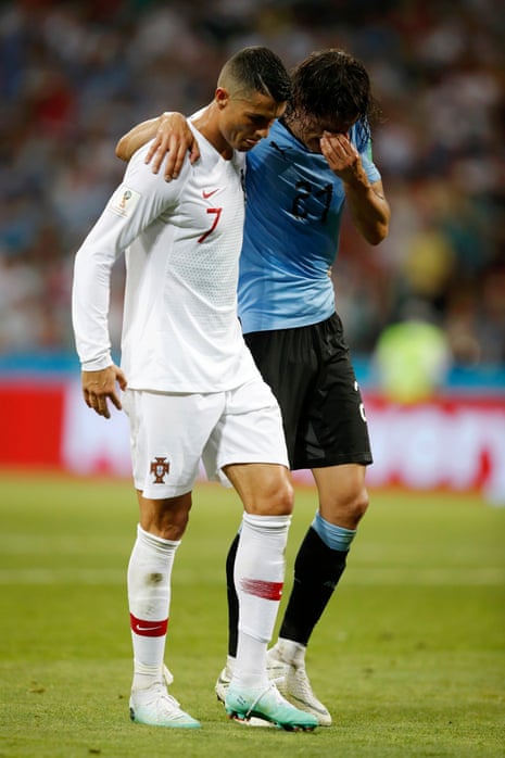 Cristiano Ronaldo helps Edinson Cavani off the pitch.