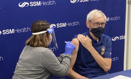 Governor Tony Evers receives his vaccination for the coronavirus from registered nurse Bobbie Rogers in Madison, Wisconsin on 13 March. Vaccine hesitancy appears strongest where distrust of government institutions is greatest.