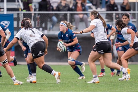 Georgie Perris-Redding carries the ball, chased by opponents in white kit during a match