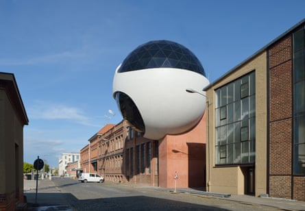 Niemeyer's giant white sphere perches on top of a traditional brick industrial building