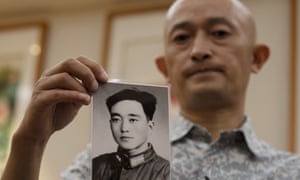 Zhang Hai holds up a photo of his father taken in his youth during an interview in Shenzhen in southern China’s Guangdong province