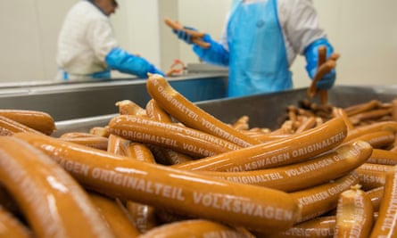 Employees package beech wood-smoked currywurst sausages on the production line