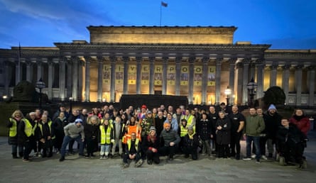 A group of people in high vis and hats and winter coats in Liverpool outside a civic building