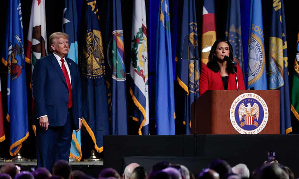 Donald Trump watches Tulsi Gabbard as she speaks at a lectern decorated with the Great Seal of the United States. There are an array of flags in the background