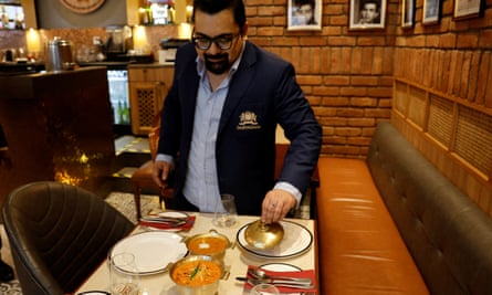 Amit Bagga, CEO of Daryaganj restaurant, shows a freshly prepared butter chicken dish and the lentil dish dal makhani, inside Daryaganj restaurant in Noida