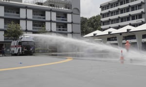 An anti-riot vehicle equipped with water cannon sprays water on a dummy during a demonstration in Hong Kong on Monday.