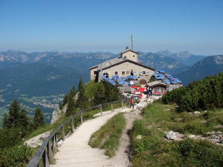 The Eagle's Nest building with blue umbrellas sits atop a mountain near Berchtesgaden, Germany