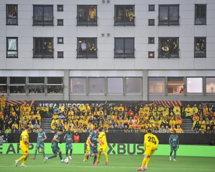 Spectators dressed in yellow in the stands and overlooking apartments at Aspmyra Stadium enjoy Bodø/Glimt’s moment in the Europa League spotlight against Spurs.