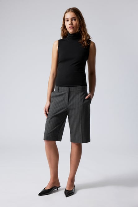 Model wearing grey pinstripe Bermuda shorts and black top