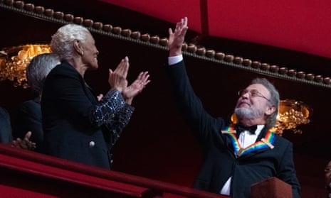 Billy Crystal waves as he is applauded by Dionne Warwick