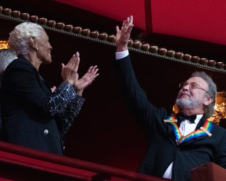 Billy Crystal waves as he is applauded by Dionne Warwick