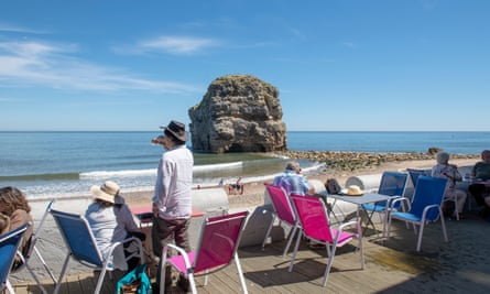 Marsden Rock with beach and people in chairs