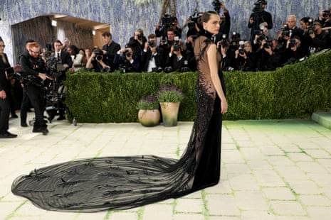 woman poses in black dress with long train