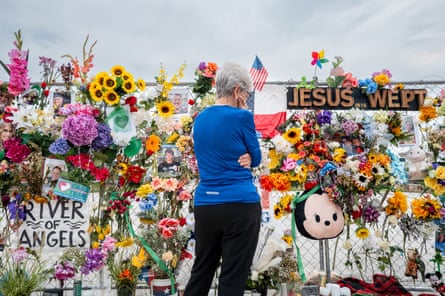 A woman looks at floral tributes.