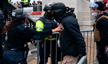 A protester confronts police officers as Trump supporters riot outside the US Capitol on 6 January.