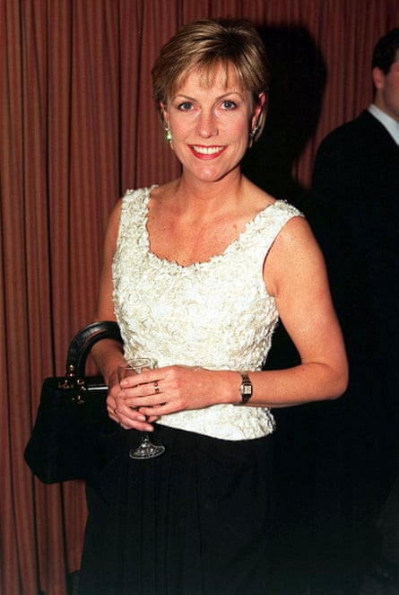 Jill Dando holds glass and handbag.