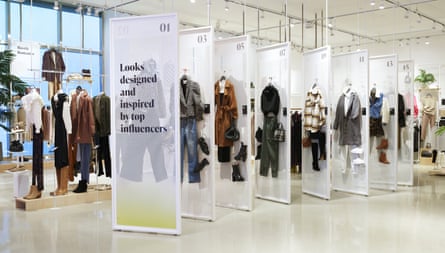 Clothes are displayed on white grids in a brightly lit store. A sign reads ‘Looks designed and inspired by top influencers’.