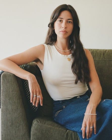 A woman poses on a couch