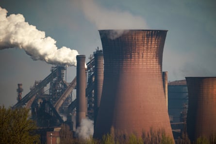 Closeup of the blast furnace chimneys, with smoke billowing into the sky.