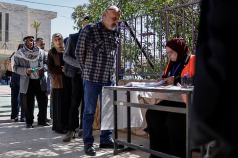 People queue to vote at a polling station.
