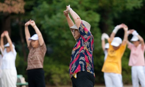 People exercise to an NHK radio calisthenics broadcast at a park in Tokyo. 