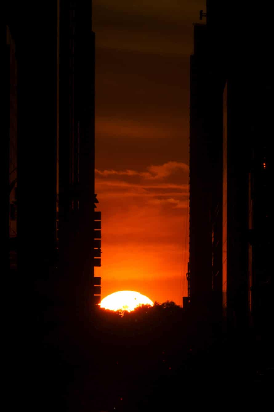 The setting sun aligns with New York architecture on 27 May.