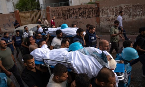 Members of the press, on 10 October, helping to carry the bodies of two Palestinian reporters killed by an Israeli airstrike in Gaza