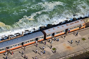 aerial photo of a train next to the sea
