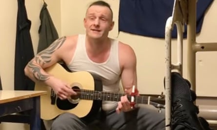 Screengrab of Joe Outlaw playing a guitar in a prison cell