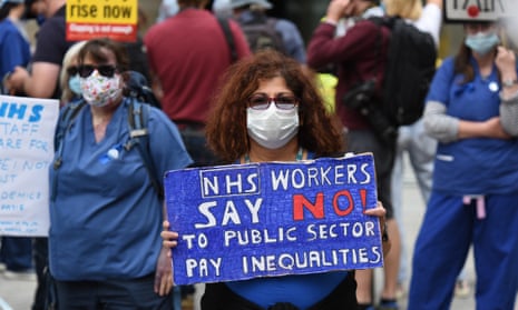A woman in a face mask at a demonstration  holding up a sign saying 'NHS workers say no to public sector pay inequaliies'