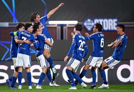 Como players celebrate a goal together on the pitch, one leaping with arm raised