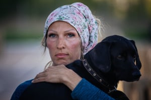 A woman holds her dog after arriving from Russian-occupied territory at a registration and processing area for internally displaced people in Zaporizhzhia