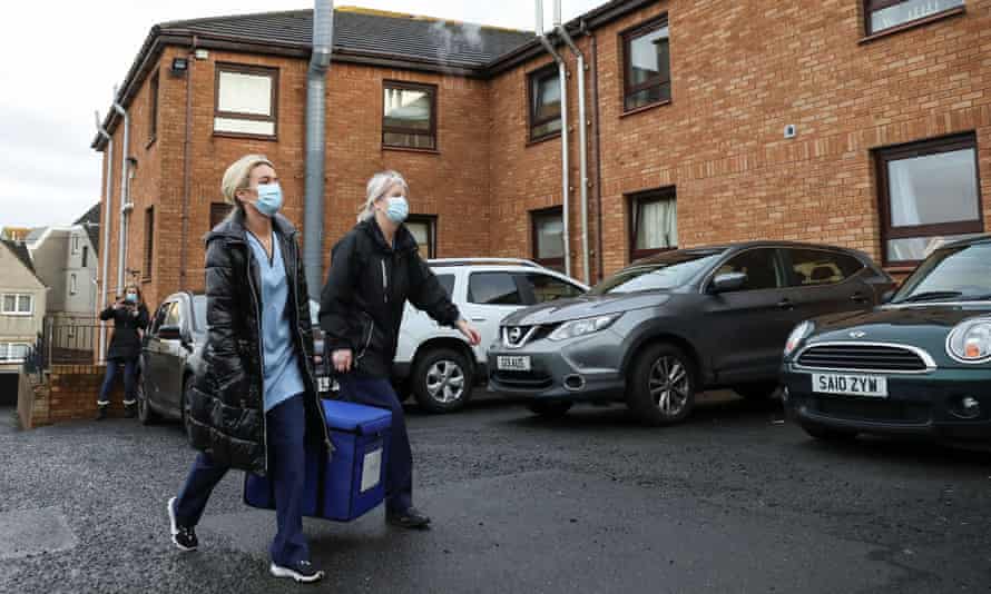 Healthcare workers carry a bag containing Pfizer/BioNTech Covid-19 vaccinations as they arrive at the Abercorn House care home in Hamilton, Scotland.