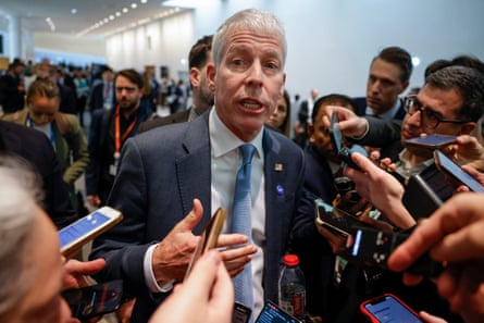 a man speaks to people holding their phones toward him