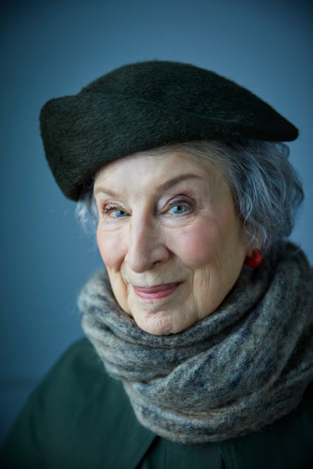A portrait of Margaret Atwood in a coat, scarf and hat