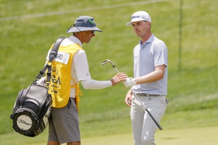 Ryan Gerard, of the US, hands his wedge to his caddie Steven Hale after an eagle on the 15th.