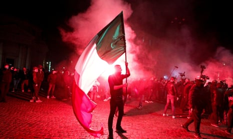 A demonstrator holds an Italian flag during a protest over restrictions put in place to curb coronavirus cases