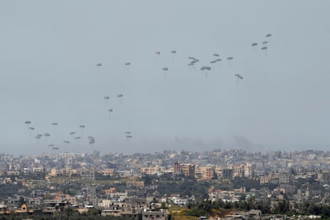 Parachutes drop supplies into the northern Gaza Strip, as seen from southern Israel on Wednesday.