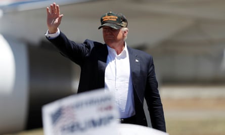 Man in baseball hat waves to crowd