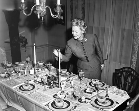 Woman lighting up candle, table ready for dessert
