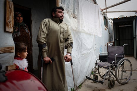 Lemeh, 34, who suffered from polio and was injured in the war, stands in the door of his family’s shelter with his mother and niece, Zahlé, Lebanon, 23 March 2021