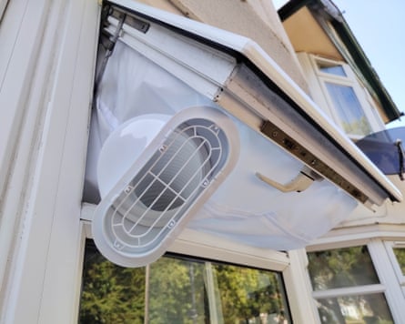 An outside view of an aircon tube vent coming through a window