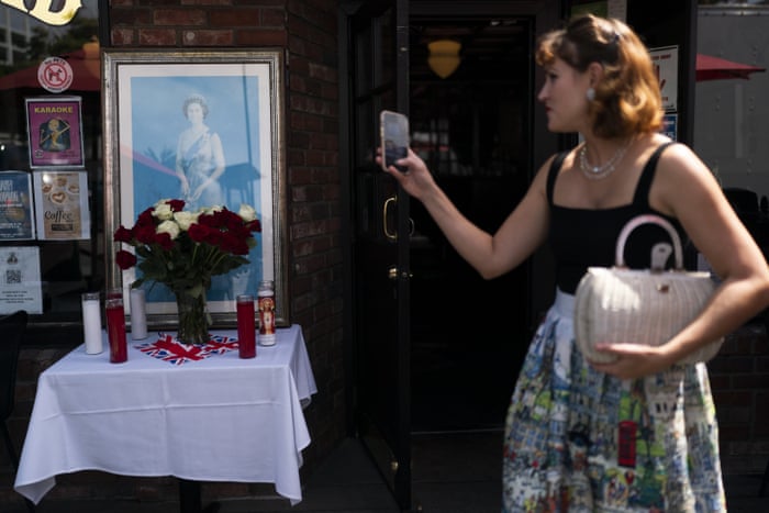 Ashley Spearman takes pictures of a memorial honoring Queen Elizabeth II at Ye Olde King's Head British restaurant in Santa Monica, California, on Thursday.