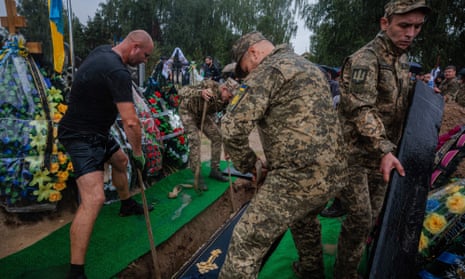 Ukrainian soldiers and a city worker bury the coffin of Ukrainian serviceman Anton Savytskyi at Bucha's cemetery in Kyiv region.