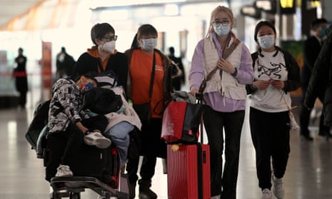 Passengers walk through an airport in Beijing.