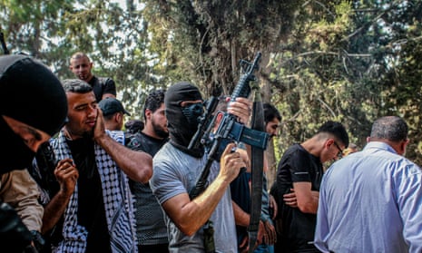 A masked gunman takes part in the funeral on Monday of two Palestinian men, 29-year-old Jihad Saleh, and 17-year-old Mohammed Abu Zer who were killed during an Israeli raid on the village of Zawata, west of the city of Nablus in the Israeli occupied West Bank.