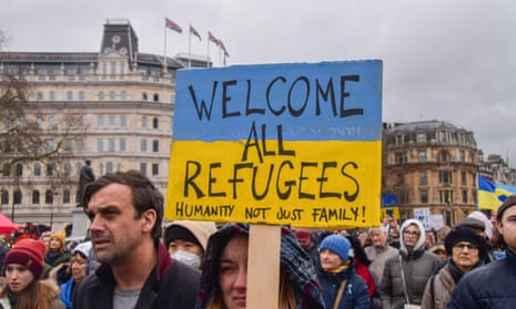 A protester holds a 'Welcome All Refugees' placard at a protest in London on 5 March.